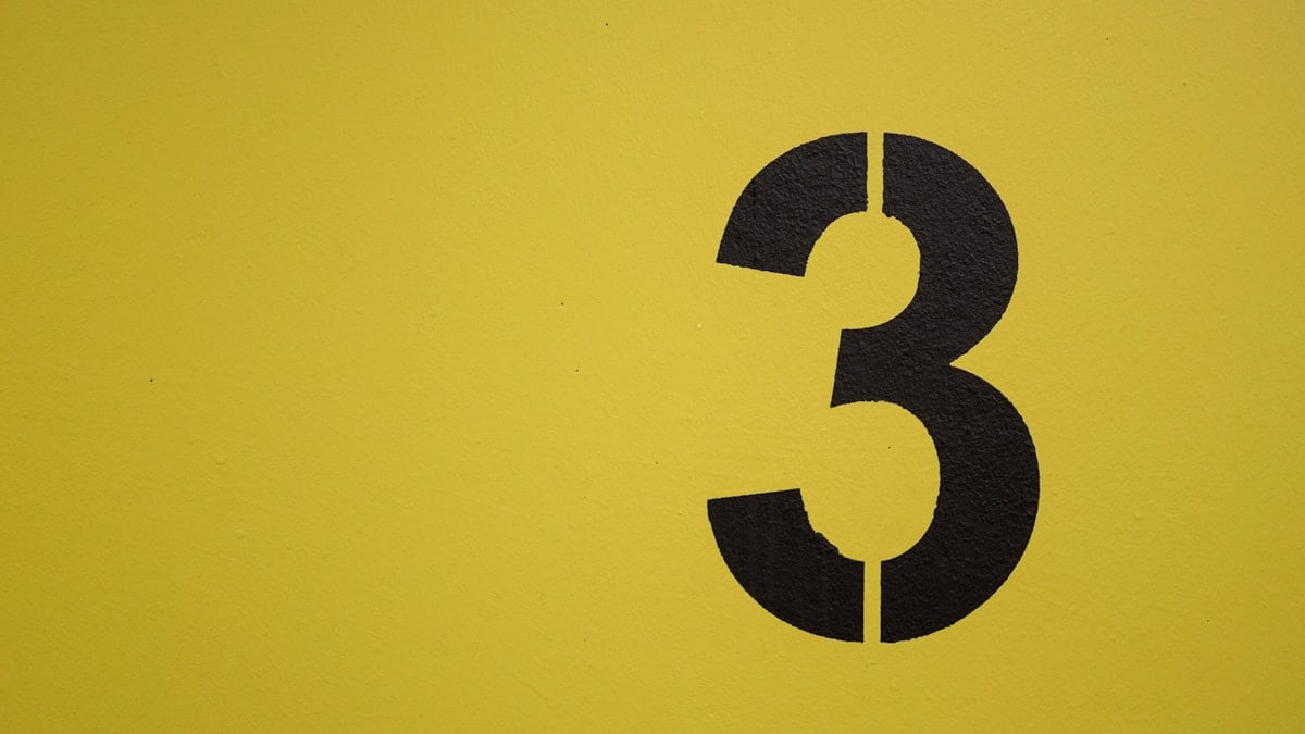 Black number three stenciled on yellow background